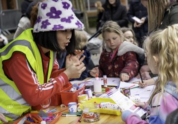 A young Asian girl at an arts and craft table with young children